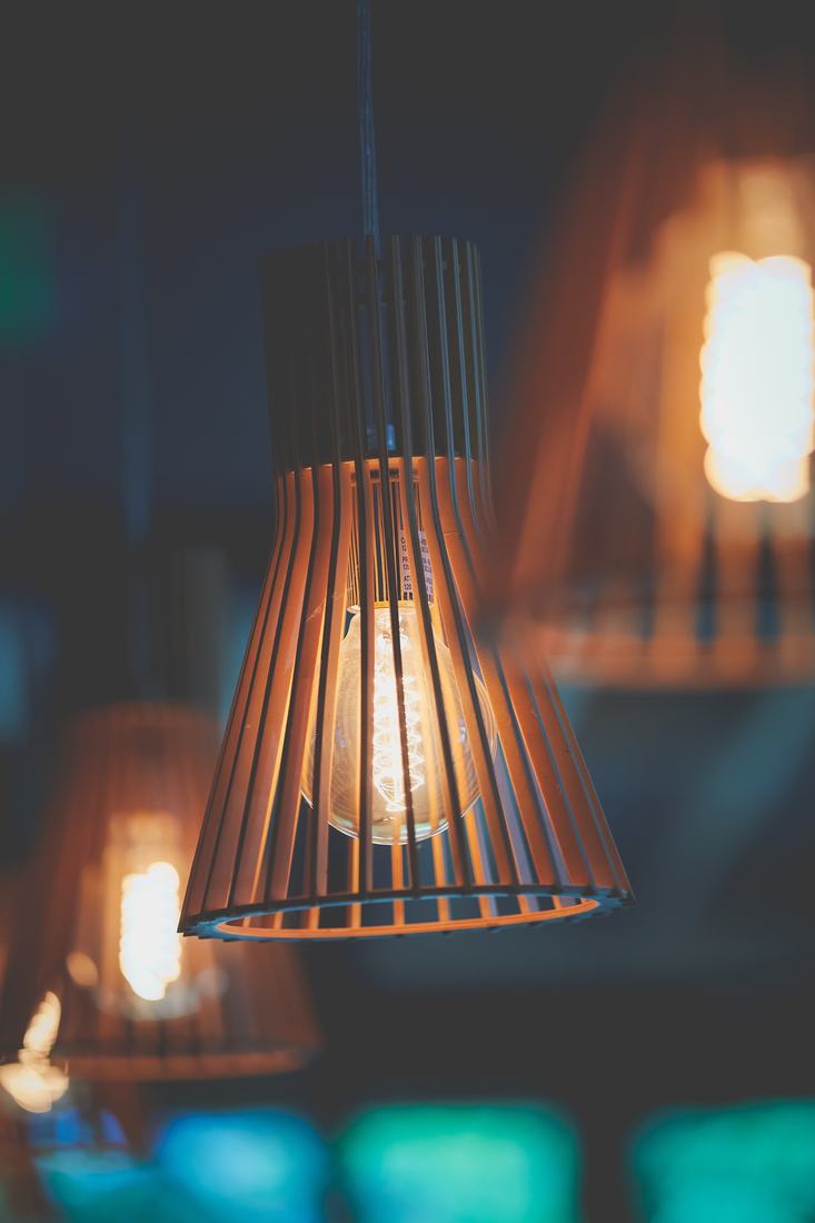 A slatted wood pendant lamp glowing warmly over the dining room.
